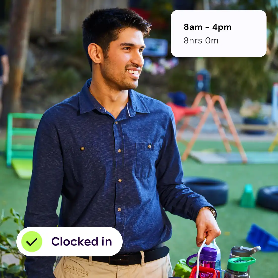 A man holding two bottles of water, one in each hand, standing against a neutral background.