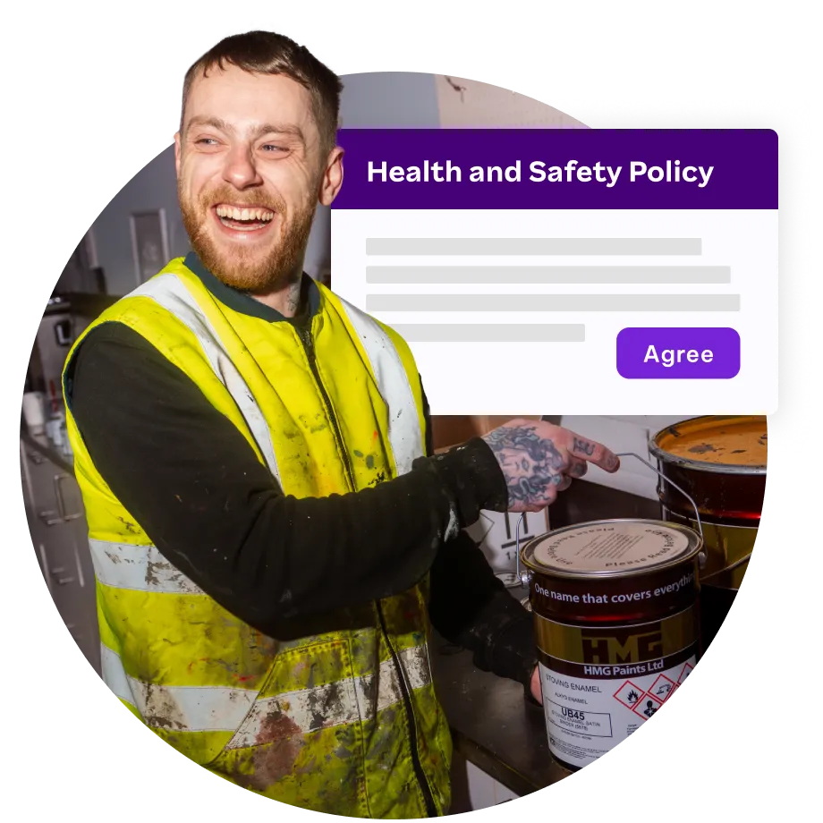 A construction worker wearing a high-visibility yellow vest smiles while pointing at a can of paint. In the background, a digital overlay displays a "Health and Safety Policy" document with an "Agree" button, symbolizing policy acknowledgment.