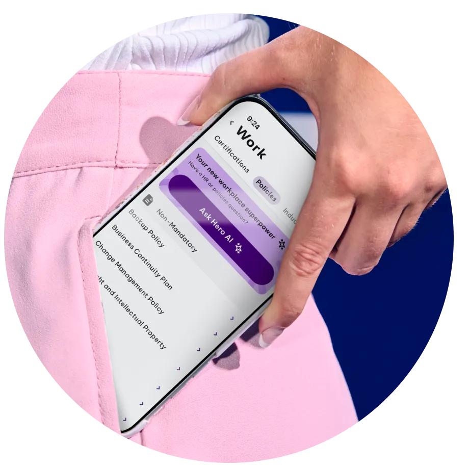 A person places a smartphone into the pocket of pink pants. The phone screen displays a work-related app showing company policies, including "Anti-Discrimination Policy," "Code of Conduct," and "Health and Safety Policy," along with options to view and acknowledge them.