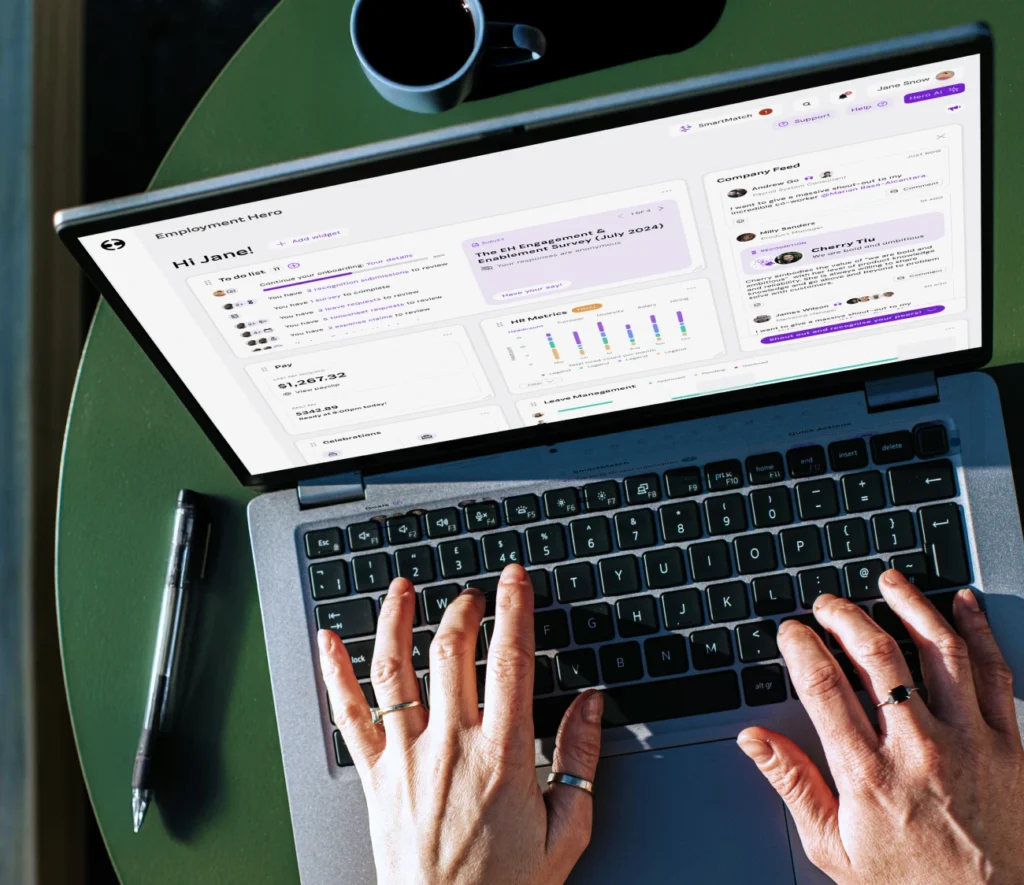 Hands typing on a laptop showing an employee dashboard interface from Employment Hero.