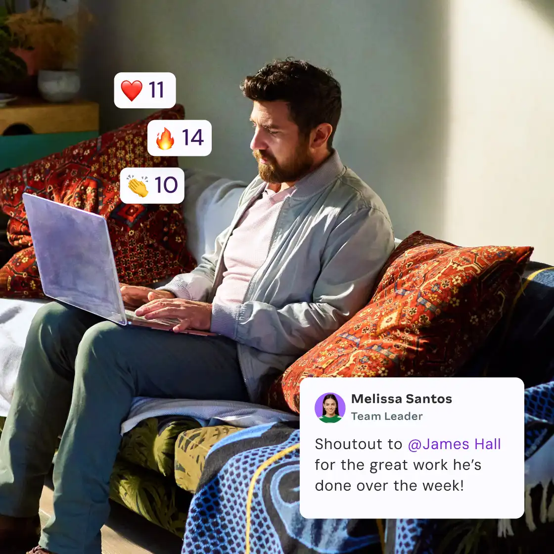 A man sitting on a couch, focused on his laptop, with a relaxed expression in a cozy living room setting.